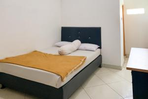 a bed with two pillows on it in a room at Penginapan Losmen Ayu Pamanukan RedPartner in Pamanukan-hilir