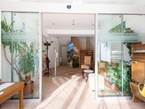 ヴァルト・イム・ピンツガウにあるLovely Apartment with Sauna Ski Storage Pool Terraceのガラス張りの壁と鉢植えの植物が備わるお部屋