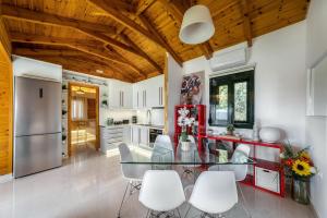 a kitchen with a glass table and white chairs at Sofia's Place in Heraklio Town