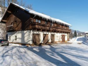 a wooden barn with snow on the side of it at detached modern holiday home with sauna in the Salzburgerland in Bruck an der Großglocknerstraße