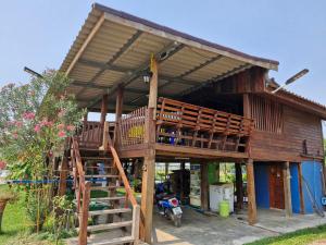 a large wooden house with a large deck at Yungthong Baan Suan Resort in Ban Ko