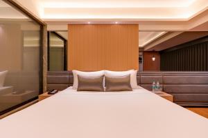 a bedroom with a large white bed and a bath tub at Lemon Tree Premier, Malad, Mumbai in Mumbai