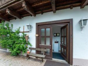 ブルック・アン・デア・グロースグロックナーシュトラーセにあるdetached modern holiday home with sauna in the Salzburgerlandの木製の扉とベンチのある家の入口