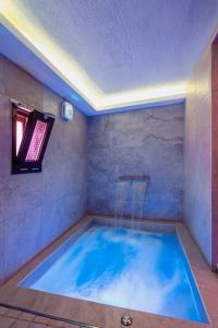 a large blue tub in a room with a ceiling at LUXUITE SPA con PISCINA e JACUZZI in Alberobello