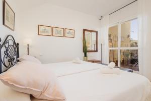 マルベーリャにあるBeautiful beachside duplex apartment with amazing sea viewsの白いベッドルーム(窓付)の白いベッド2台