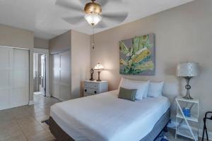 a bedroom with a white bed and a ceiling fan at Charming 1st floor apt in the heart of Springfield in Jacksonville