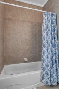 a bathroom with a bath tub with a blue shower curtain at Charming 1st floor apt in the heart of Springfield in Jacksonville