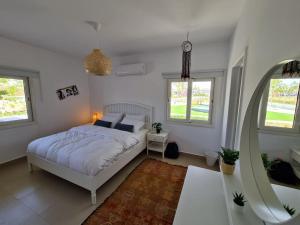 a white bedroom with a bed and a mirror at Almaza Bay Beachtown Ground Chalet in Marsa Matruh