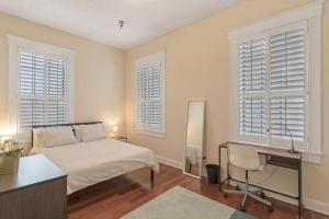 a bedroom with a bed and a desk and windows at LT Stay Discounts! Cozy 2 BR Apt - Pet Friendly! in Jacksonville