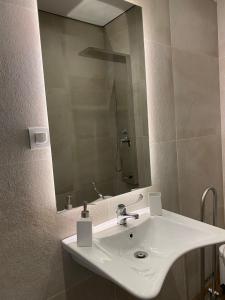 y baño con lavabo blanco y espejo. en Monastiri Mountain Escape, en Konitsa