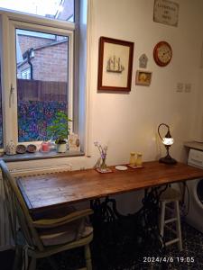 een houten tafel in een kamer met een raam bij Captivating 2-Bed Hideaway Apartment in Gloucester in Gloucester