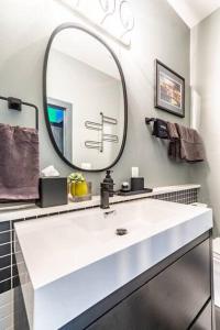 een badkamer met een witte wastafel en een spiegel bij Unique studio w pool spa & gardens near downtown in Jacksonville