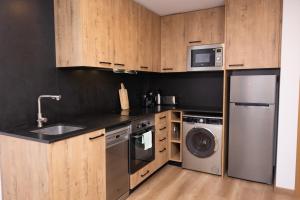 eine Küche mit Küchengeräten aus Edelstahl und Holzschränken in der Unterkunft APM Manresa in Manresa