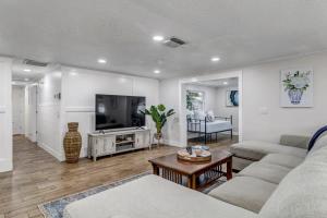 a living room with a couch and a flat screen tv at Spacious Home w Pool-Tucked Away in Jax Beach in Jacksonville Beach