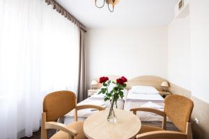 a table with a vase of roses on it at Rewita Międzyzdroje Neptun in Międzyzdroje