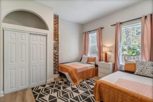 um quarto com 2 camas e uma janela em Elegant 2 BR apt in the heart of historic SPR - 5 min drive to TIAA Bank Field em Jacksonville