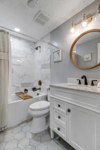 a bathroom with a toilet and a sink and a mirror at Spacious Home w Pool-Tucked Away in Jax Beach in Jacksonville Beach