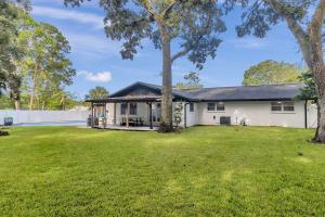 an exterior view of a white house with a yard at Spacious Home w Pool-Tucked Away in Jax Beach in Jacksonville Beach