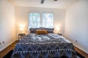 a bedroom with a large bed with two windows at Charming Riverside Retreat 1 1 - Near 5 Points #3 in Jacksonville