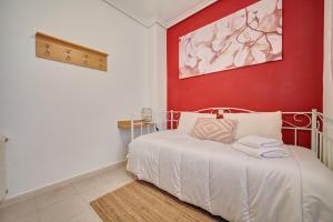 a bedroom with a white bed with a red wall at La Kasilla de Viana by Clabao in Viana