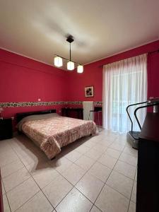 a bedroom with a bed in a red wall at Ήσυχο διαμέρισμα στην Ελευσίνα in Elefsina