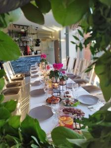 uma mesa longa com pratos de comida e flores em Audrės namai em Mozūriškiai