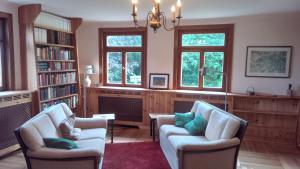 a living room with two chairs and two windows at Feriendomizil Nordschwarzwald in Neuweiler