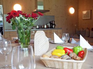una mesa con una cesta de verduras y un jarrón de flores en Grand Apartment in Mayrhofen with Infrared Sauna Artistic Interiors, en Ramsau im Zillertal