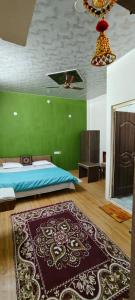 een slaapkamer met een bed en een groene muur bij Krishnashry Home in Ujjain