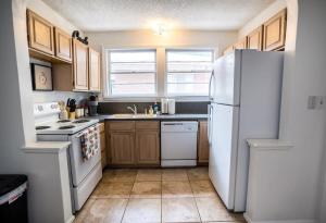 a kitchen with a white refrigerator and wooden cabinets at Charming Riverside Retreat 1 1 - Near 5 Points #4 in Jacksonville