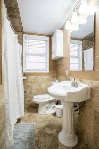 La salle de bains est pourvue d'un lavabo blanc et de toilettes. dans l'établissement Charming Riverside Retreat 1 1 - Near 5 Points #2, à Jacksonville