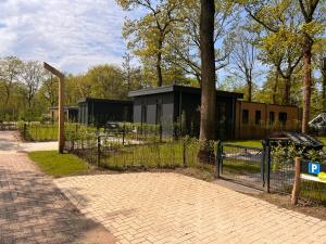 een hek met een zwart gebouw in een park bij Park Drentheland in Zorgvlied