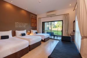 a hotel room with two beds and a balcony at Blu Monkey Brown House Udonthani in Udon Thani