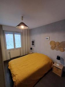 ein Schlafzimmer mit einem gelben Bett und einem Fenster in der Unterkunft Soleil d'Opale et son grand jardin in Wimereux