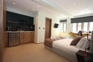 a bedroom with a large bed and a kitchen at IPELHOME-Avissinias Boutique Apartments in Athens
