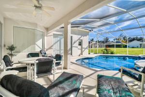 a patio with a pool and a table and chairs at Grand Luxury Deluxe 4BR Pool Home near Disney in Davenport
