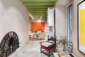 a living room with a chair and a table at Magno Apartments Almirante Hoyos House in Seville