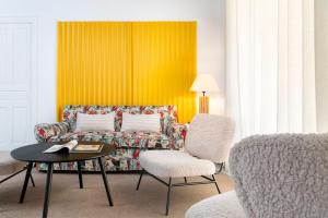 - un salon avec un canapé, une table et des chaises dans l'établissement Magno Apartments Almirante Hoyos House, à Séville