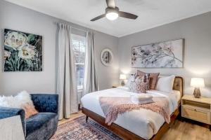 a bedroom with a bed and a couch and a fan at Farmhouse chic in San Marco - 5 min to downtown in Jacksonville