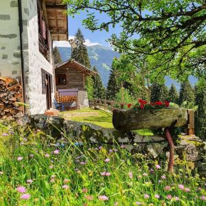 a bench with flowers on it next to a house at Baita - Chalet tra Pinzolo e Madonna di Campiglio in Madonna di Campiglio