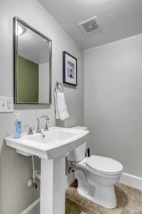 a white bathroom with a sink and a toilet at Cozy Retreat - Walkable to Bars & Restaurants in Jacksonville