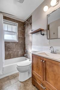 a bathroom with a toilet and a tub and a sink at Cozy Retreat - Walkable to Bars & Restaurants in Jacksonville
