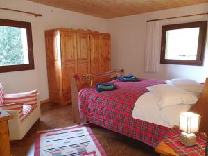 a bedroom with a bed with a red and white blanket at Baita - Chalet tra Pinzolo e Madonna di Campiglio in Madonna di Campiglio