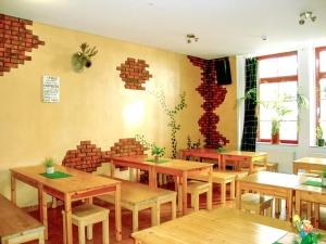 un restaurante con mesas de madera y una pared de ladrillo en Sleepy Lion Hostel & Apartments Leipzig, en Leipzig
