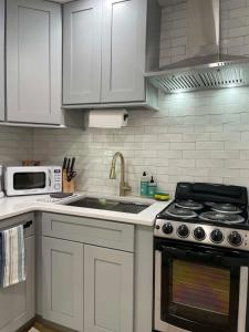 a kitchen with white cabinets and a stove top oven at Chic & Fresh 1BR Apt - 2 blocks from 5 Pts in Jacksonville