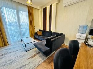 a living room with a black couch and a table at Lux Residence Next to Outlet in High Floor 26 in Istanbul