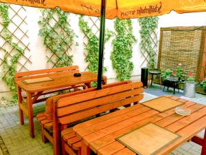 a patio with two wooden benches and an umbrella at Sleepy Lion Hostel & Apartments Leipzig in Leipzig