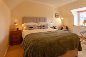 um quarto com uma cama grande e uma janela em Eilean Donan Guest House em Ullapool