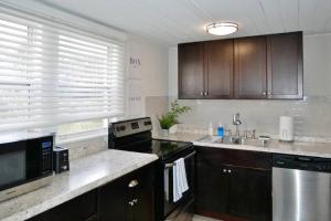 a kitchen with wooden cabinets and a counter top at Slow Pace Beach Living - Pool - Steps from Beach in Jacksonville Beach