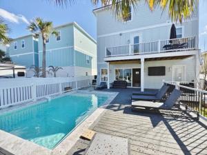 a swimming pool in front of a house at Slow Pace Beach Living - Pool - Steps from Beach in Jacksonville Beach